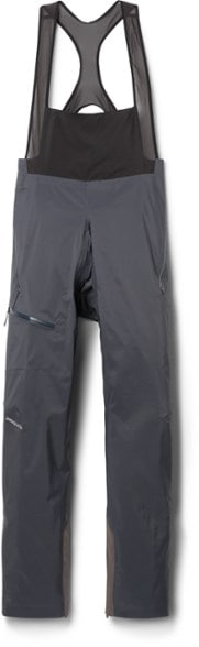 Men's bib pants shown on alpine climber ascending snow-covered peak, highlighting waterproof design