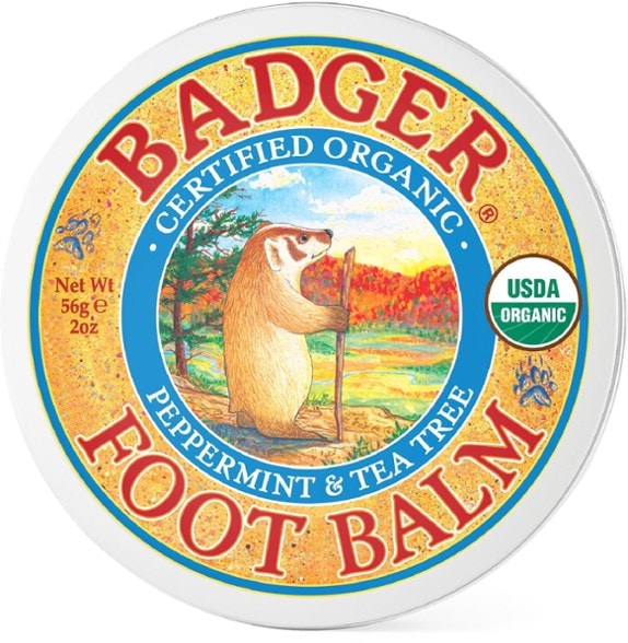 Revitalizing foot balm in a jar with natural ingredients in the background.